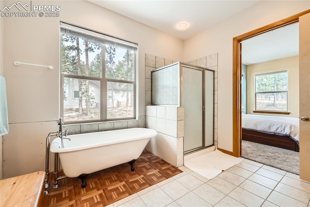 Image 18 of 50: Ensuite bathroom featuring a freestanding tub, a stall shower, ensuite bath