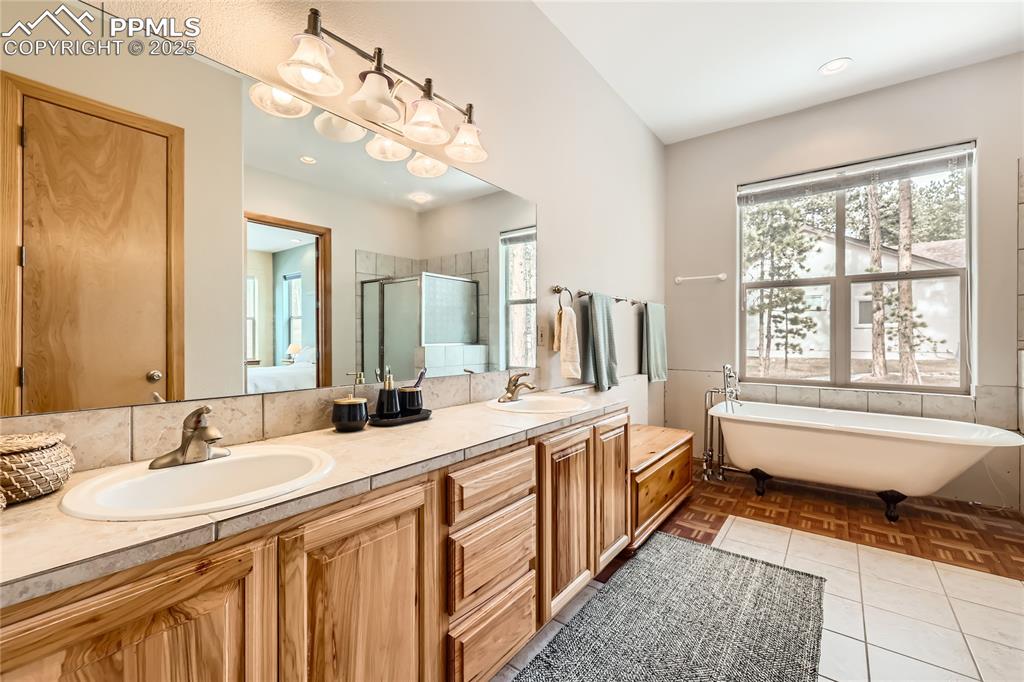 Image 20 of 50: Full bath featuring double vanity, a freestanding tub, a stall shower, and 