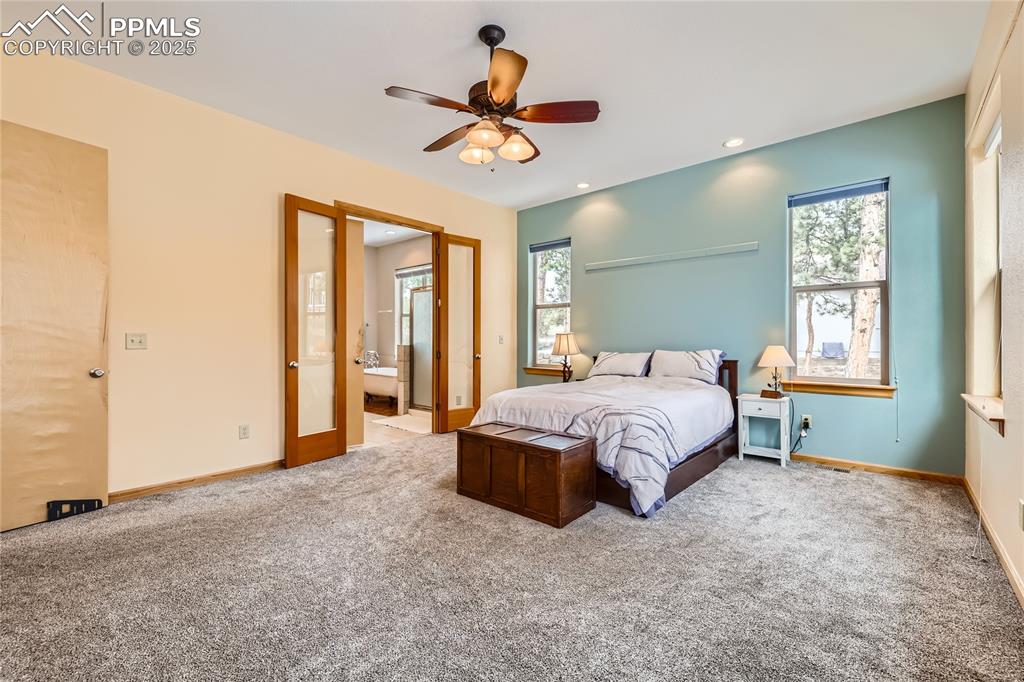 Image 22 of 50: Carpeted bedroom featuring a ceiling fan, ensuite bath, recessed lighting, 