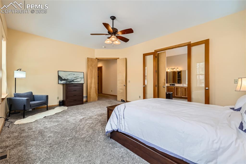 Image 23 of 50: Bedroom featuring carpet flooring, baseboards, ensuite bathroom, and ceilin