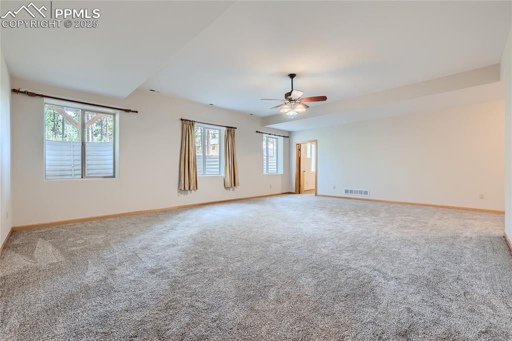 Image 31 of 50: Carpeted spare room featuring visible vents, a ceiling fan, and baseboards