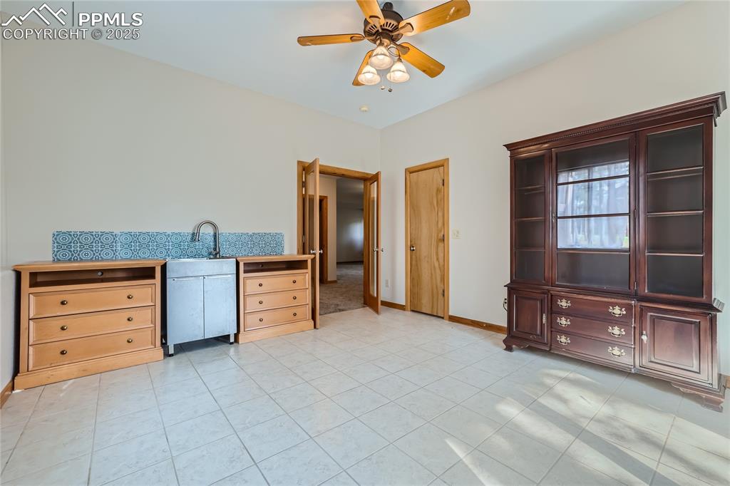 Image 36 of 50: Kitchen with a sink, baseboards, light tile patterned flooring, and a ceili