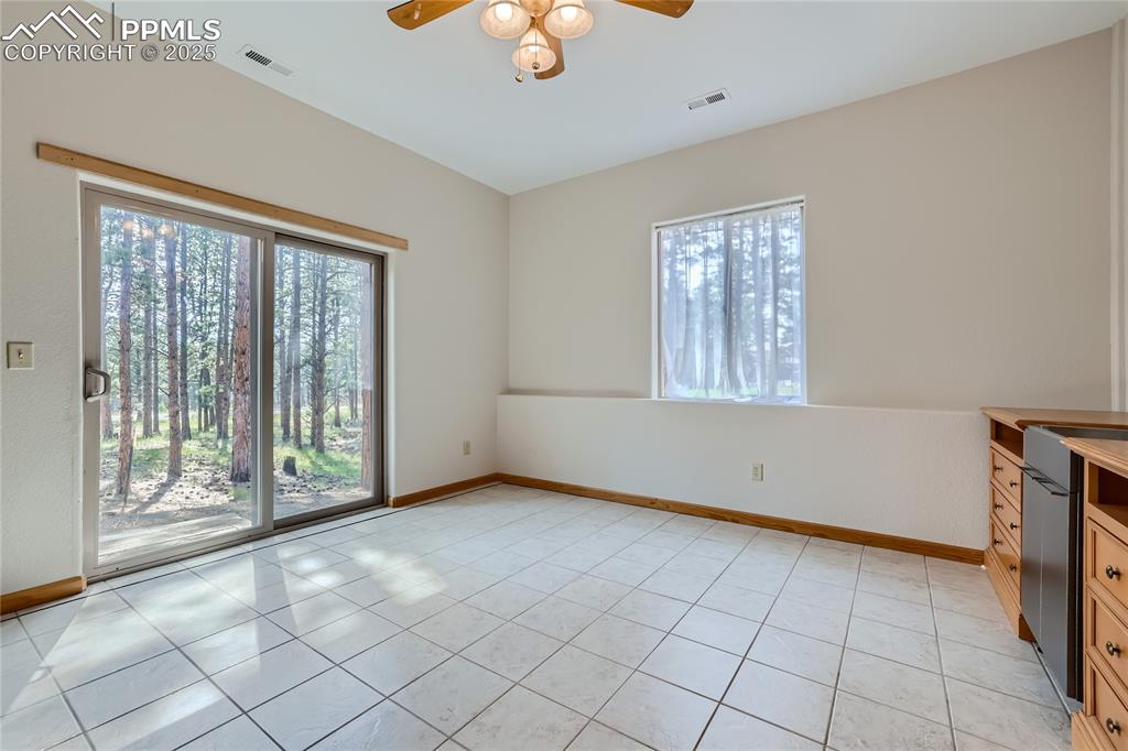 Image 37 of 50: Empty room with light tile patterned floors, baseboards, and plenty of natu