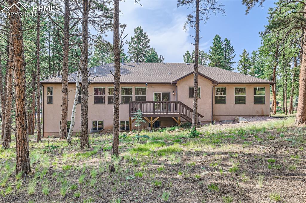 Image 38 of 50: Back of property with stucco siding, central air condition unit, a deck, an