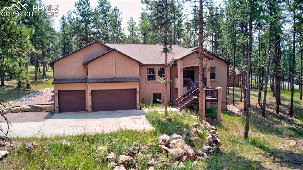 Image 39 of 50: View of front facade featuring stucco siding, driveway, and stairway