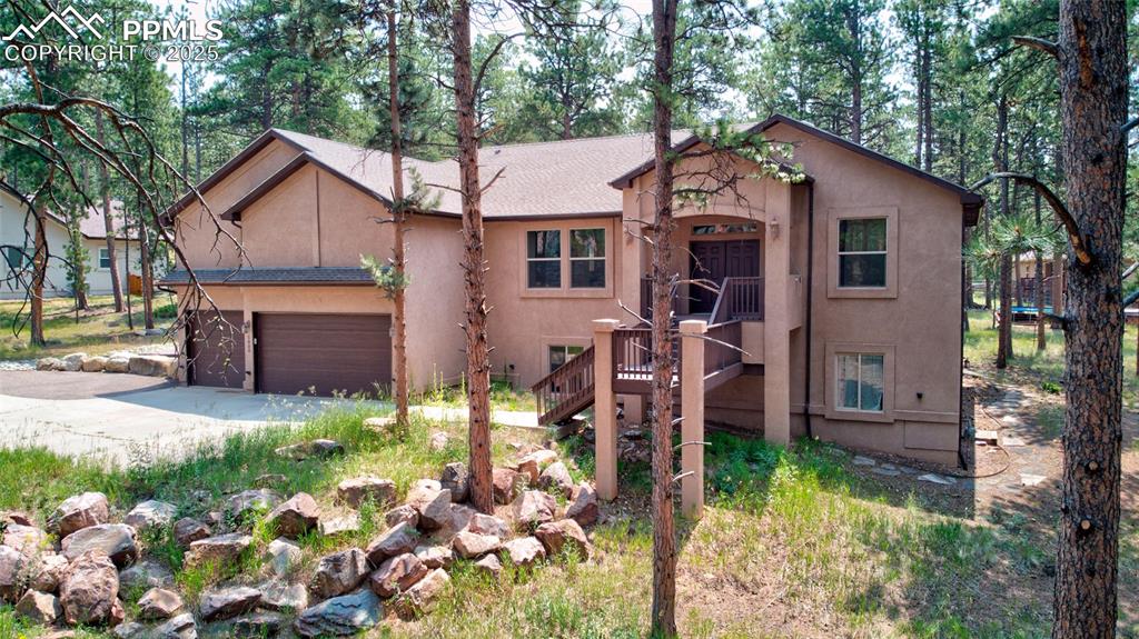 Image 40 of 50: View of front facade featuring stucco siding, an attached garage, and drive