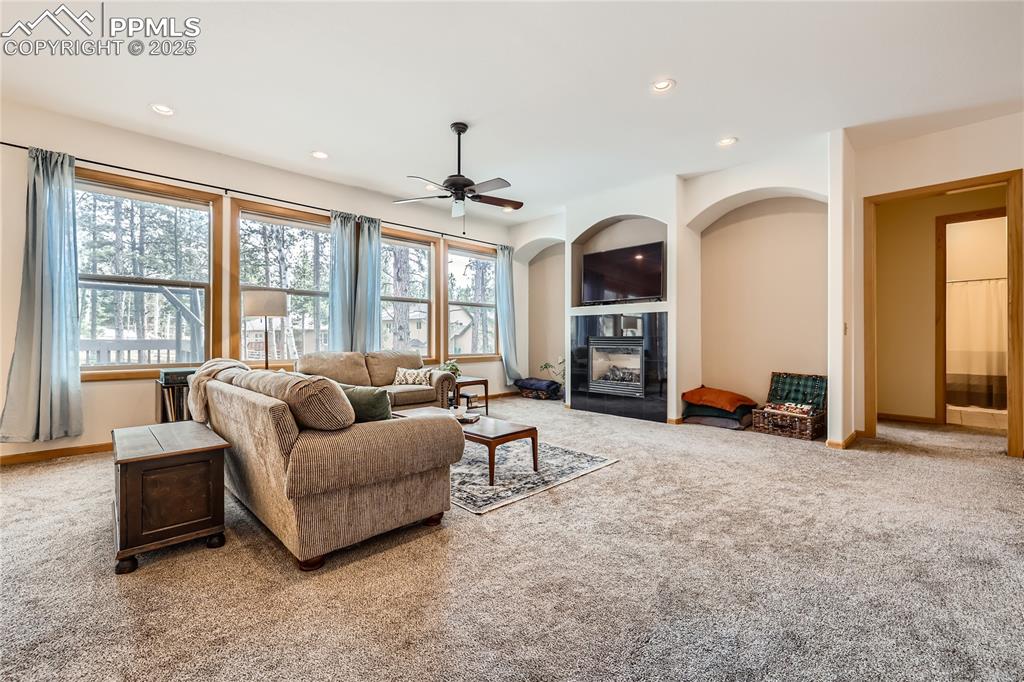 Image 7 of 50: Carpeted living room with recessed lighting, a tile fireplace, and baseboar