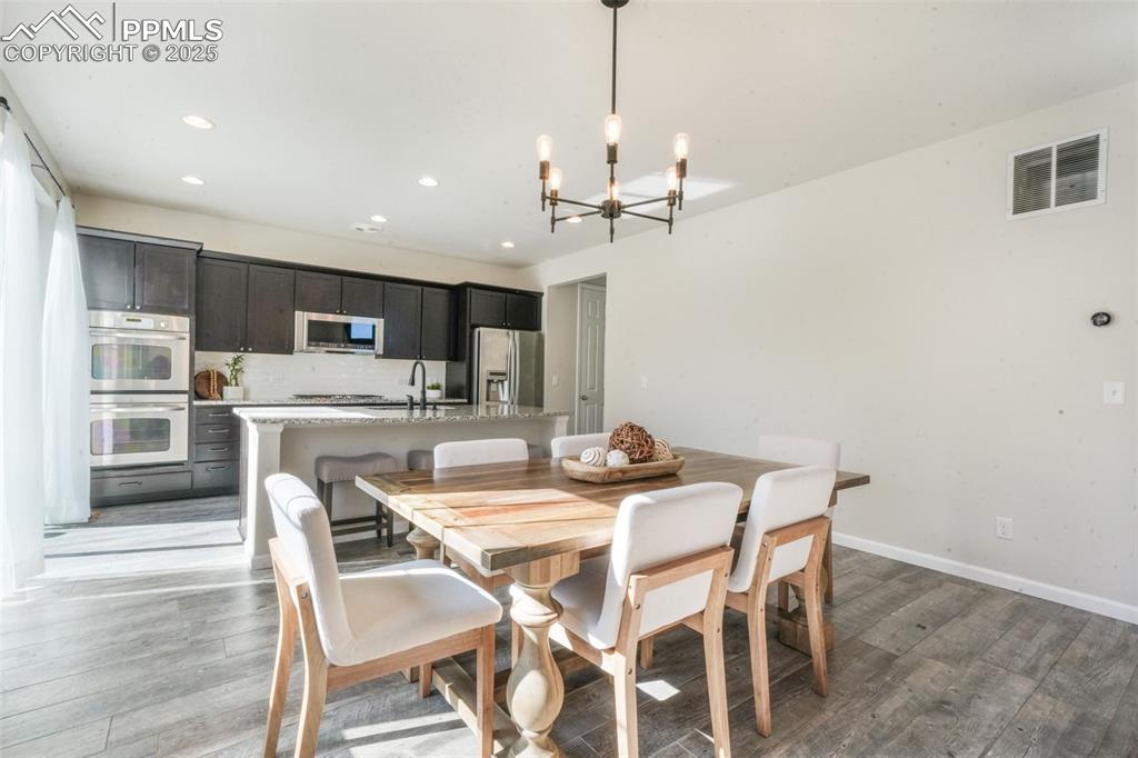 Image 11 of 50: Dining room featuring light wood-style flooring, a chandelier, and recessed