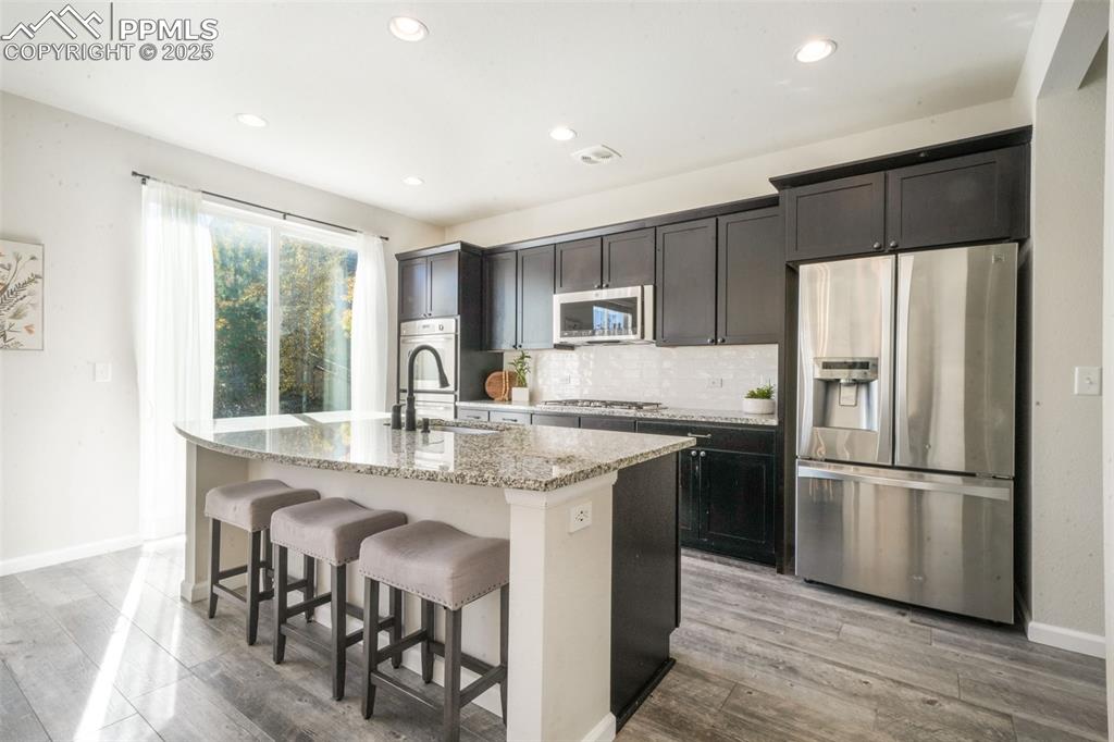 Image 13 of 50: Kitchen featuring appliances with stainless steel finishes, a kitchen break