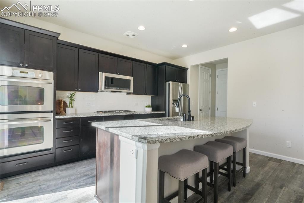 Image 14 of 50: Kitchen featuring stainless steel appliances, recessed lighting, an island