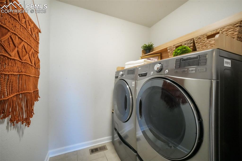 Image 19 of 50: Washroom featuring light tile patterned floors and independent washer and d