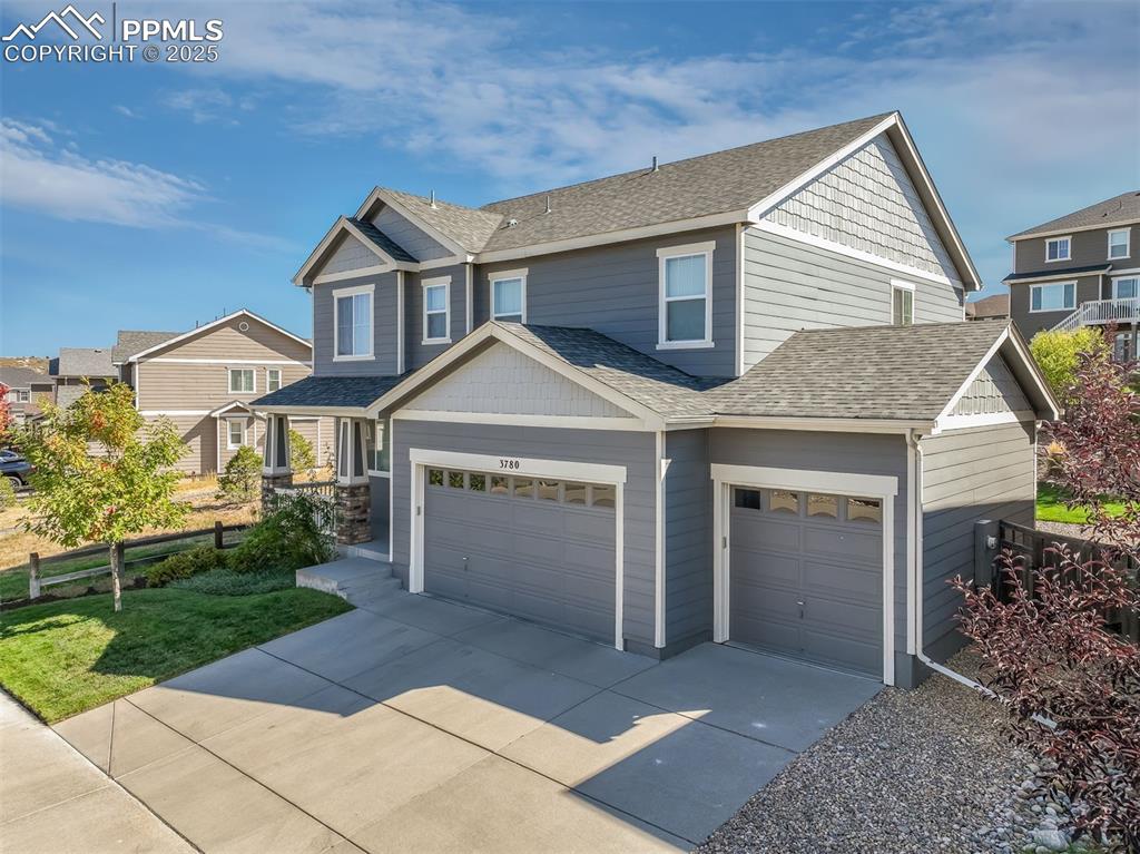 Image 2 of 50: Craftsman house with a shingled roof, concrete driveway, a residential view
