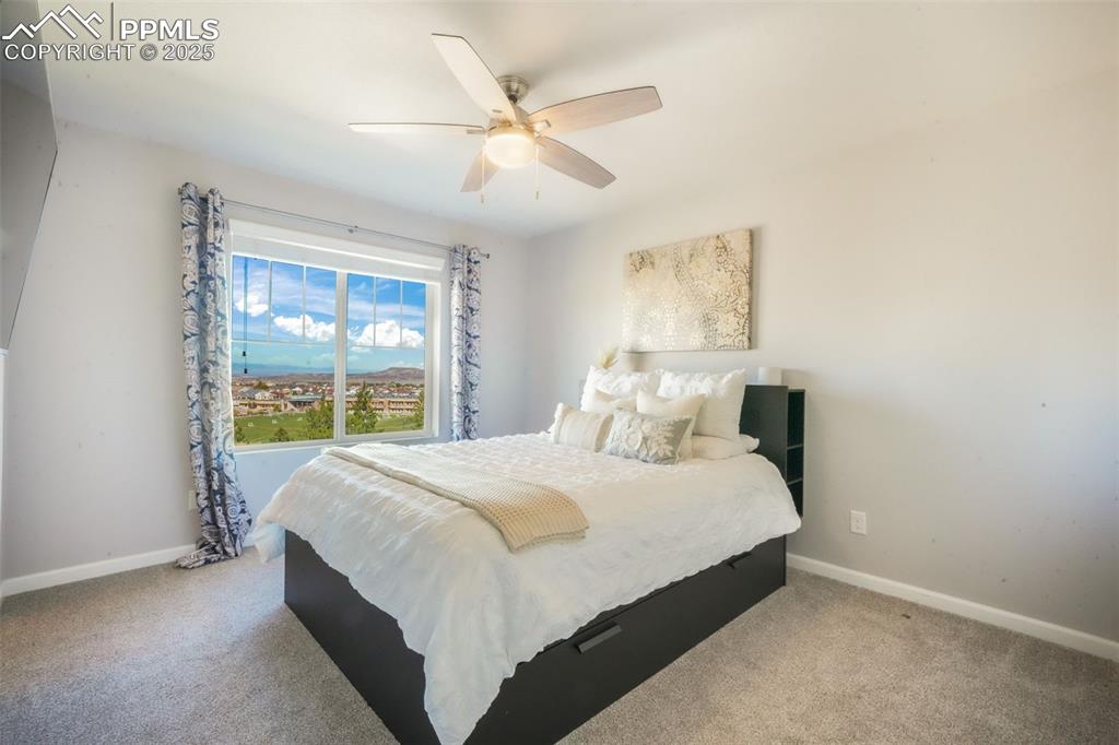 Image 34 of 50: Carpeted bedroom with a ceiling fan and baseboards