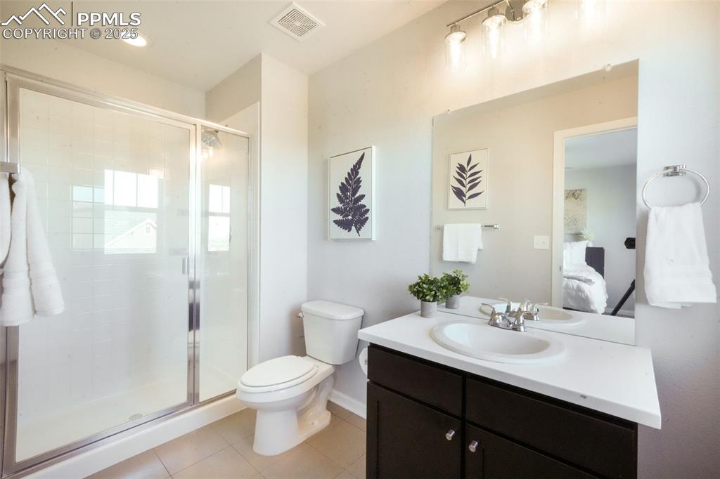 Image 35 of 50: Bathroom featuring vanity, light tile patterned floors, and a shower stall