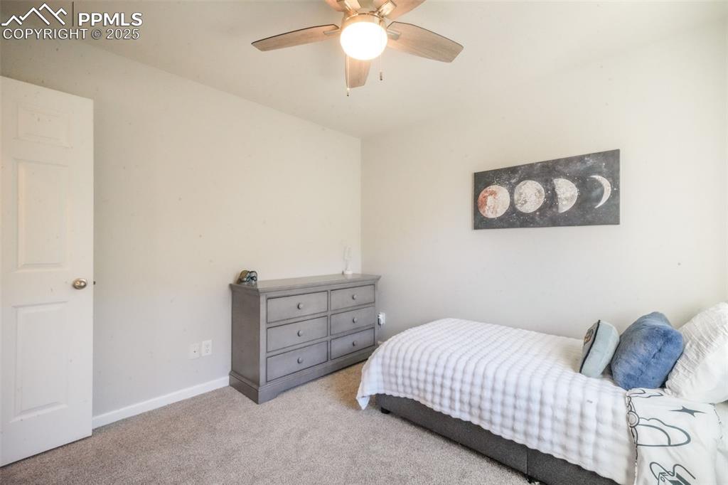 Image 39 of 50: Carpeted bedroom with baseboards and a ceiling fan
