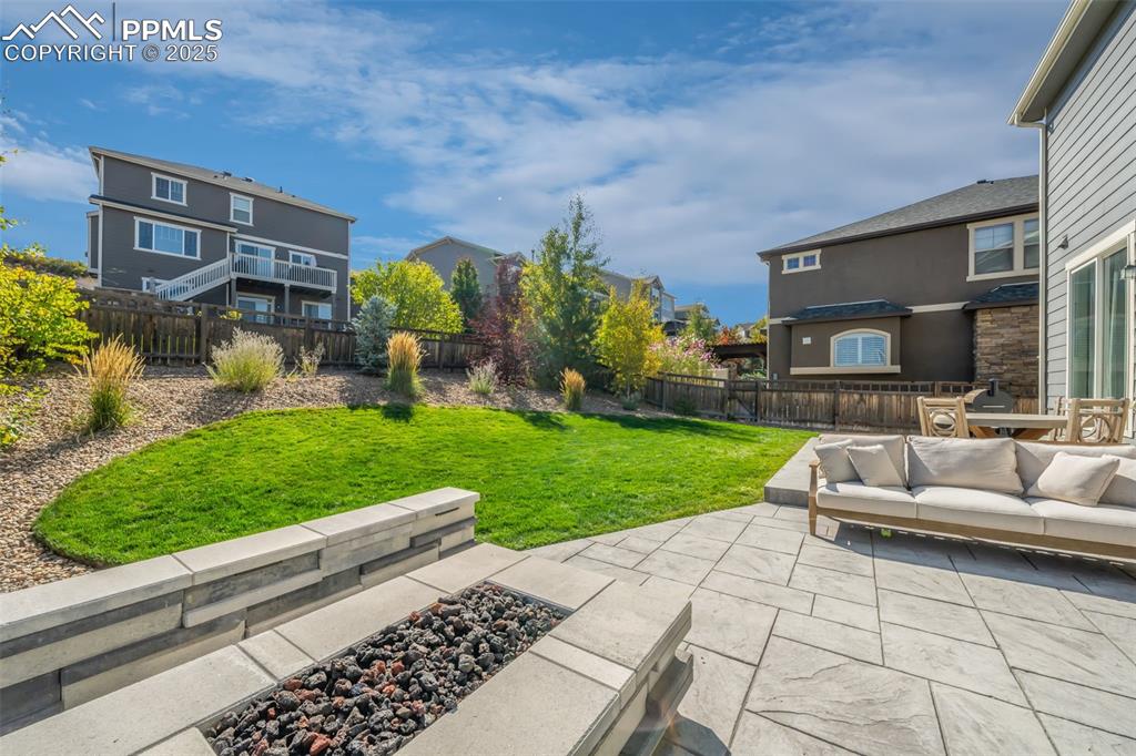 Image 47 of 50: Fenced backyard with a patio, an outdoor living space with a fire pit, and