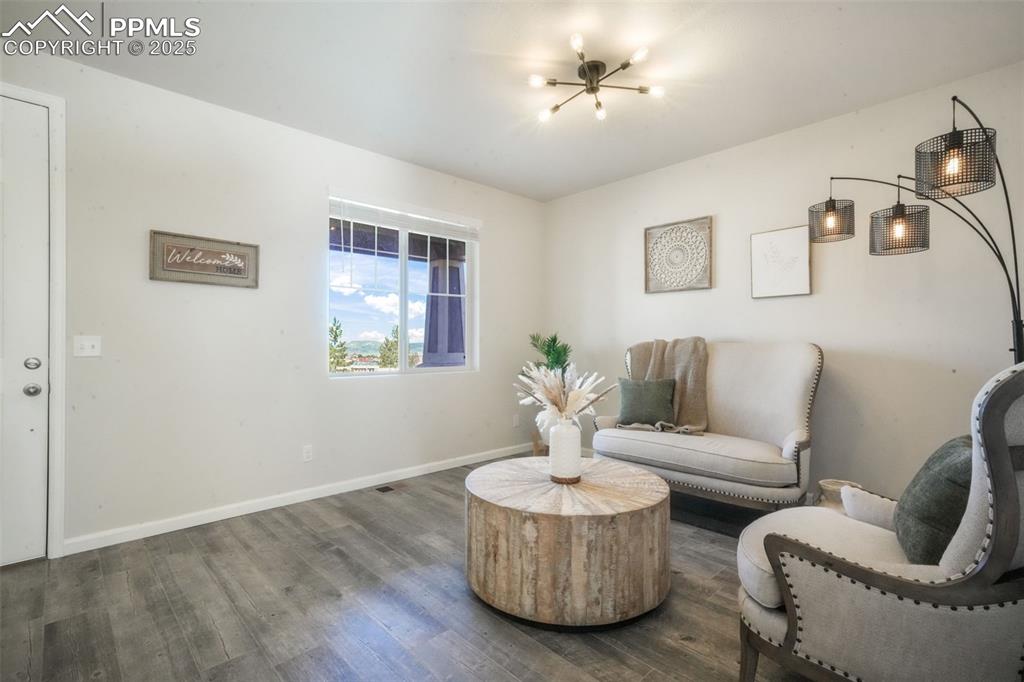 Image 6 of 50: Living area featuring dark wood-style floors and baseboards
