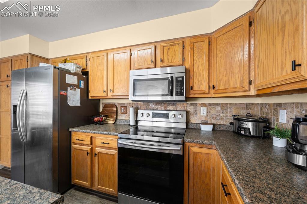 Image 3 of 30: Bright and functional kitchen showcasing honey-toned cabinetry, stainless s