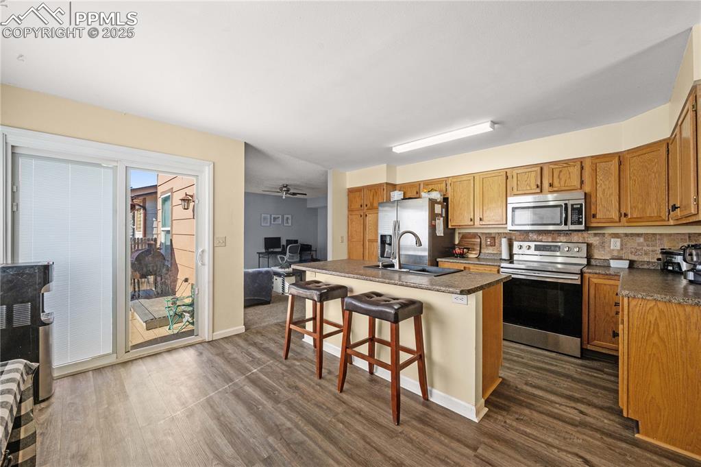 Image 4 of 30: Open-concept kitchen featuring a central island with seating for three, woo