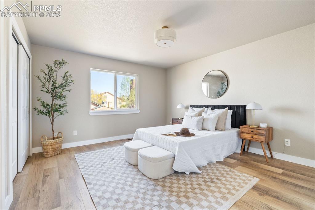 Image 17 of 26: Bedroom with light wood-style flooring and baseboards