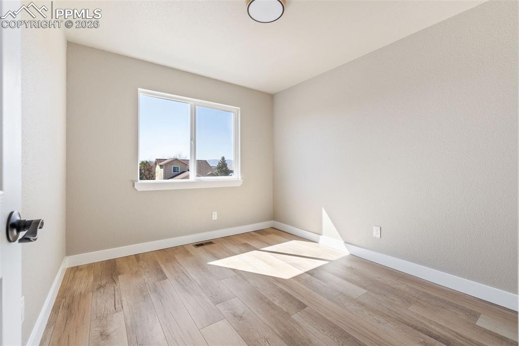 Image 21 of 26: Empty room featuring light wood-style floors and baseboards