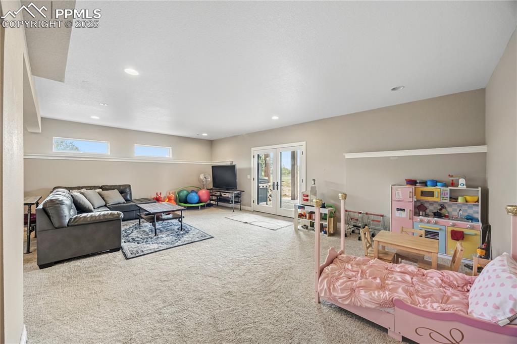 Image 13 of 40: Carpeted living area featuring french doors and recessed lighting