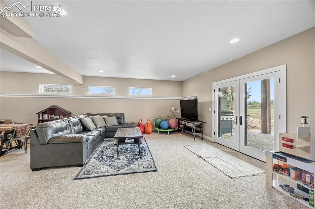 Image 14 of 40: Living room featuring french doors, carpet flooring, healthy amount of natu