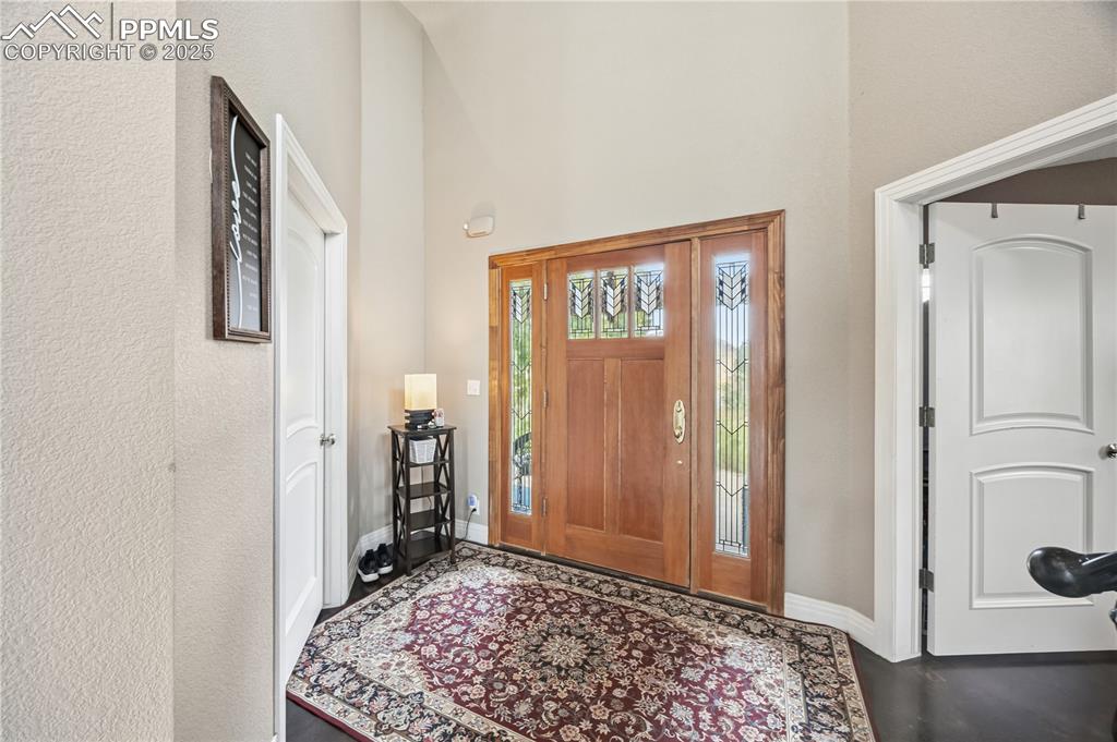 Image 2 of 40: Foyer with a textured wall and a towering ceiling