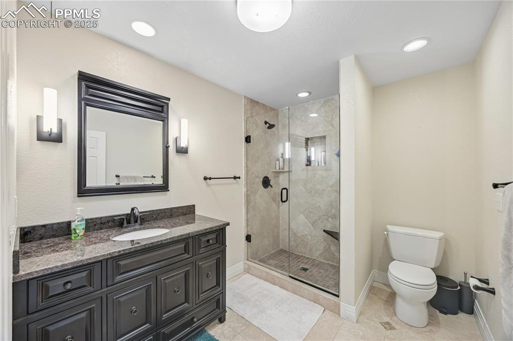 Image 21 of 40: Bathroom featuring a shower stall, vanity, light tile patterned floors, and