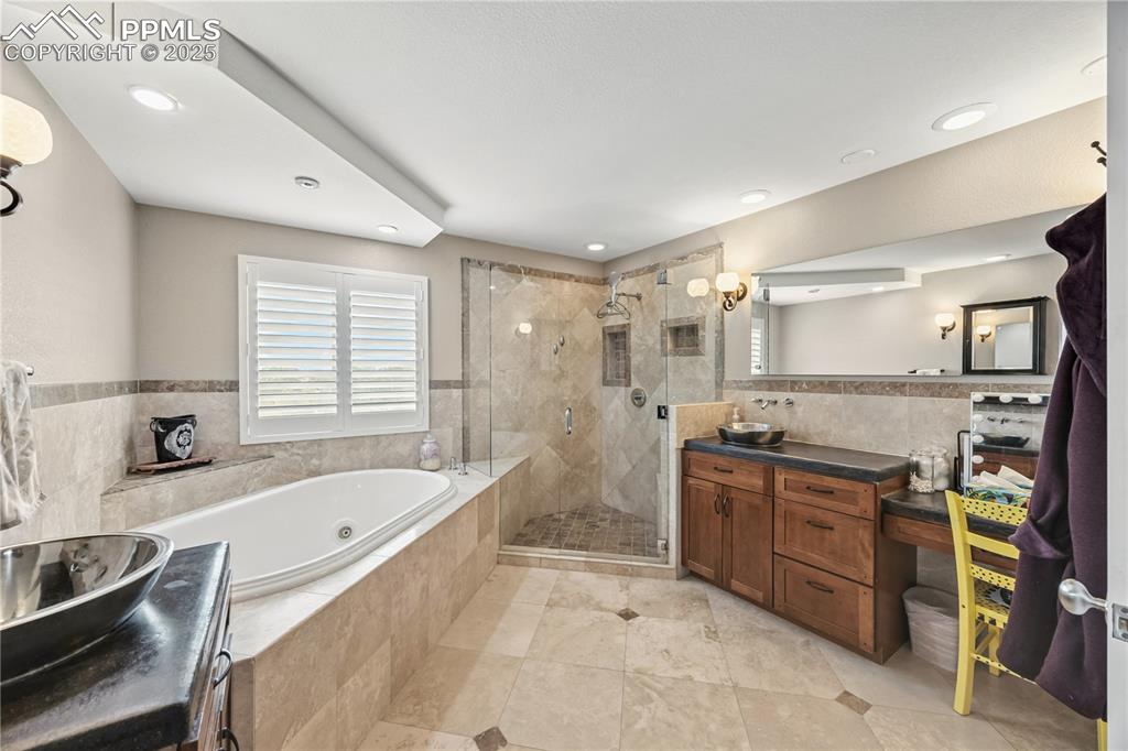 Image 26 of 40: Bathroom featuring tile walls, wainscoting, vanity, plenty of natural light