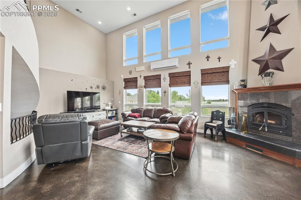 Image 4 of 40: Living room featuring a glass covered fireplace, a high ceiling, finished c