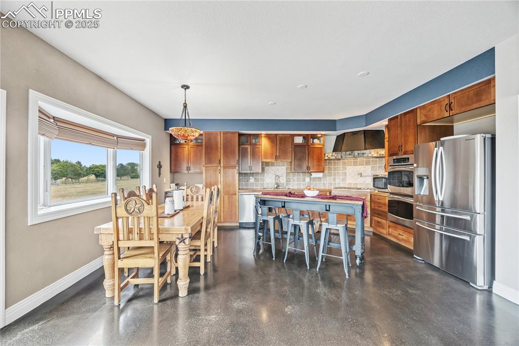 Image 8 of 40: Dining space featuring baseboards and concrete floors
