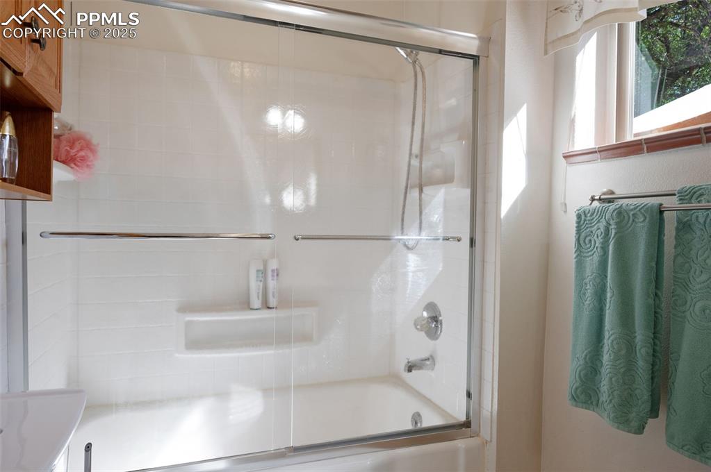 Image 18 of 27: Full bath with combined bath / shower with glass door