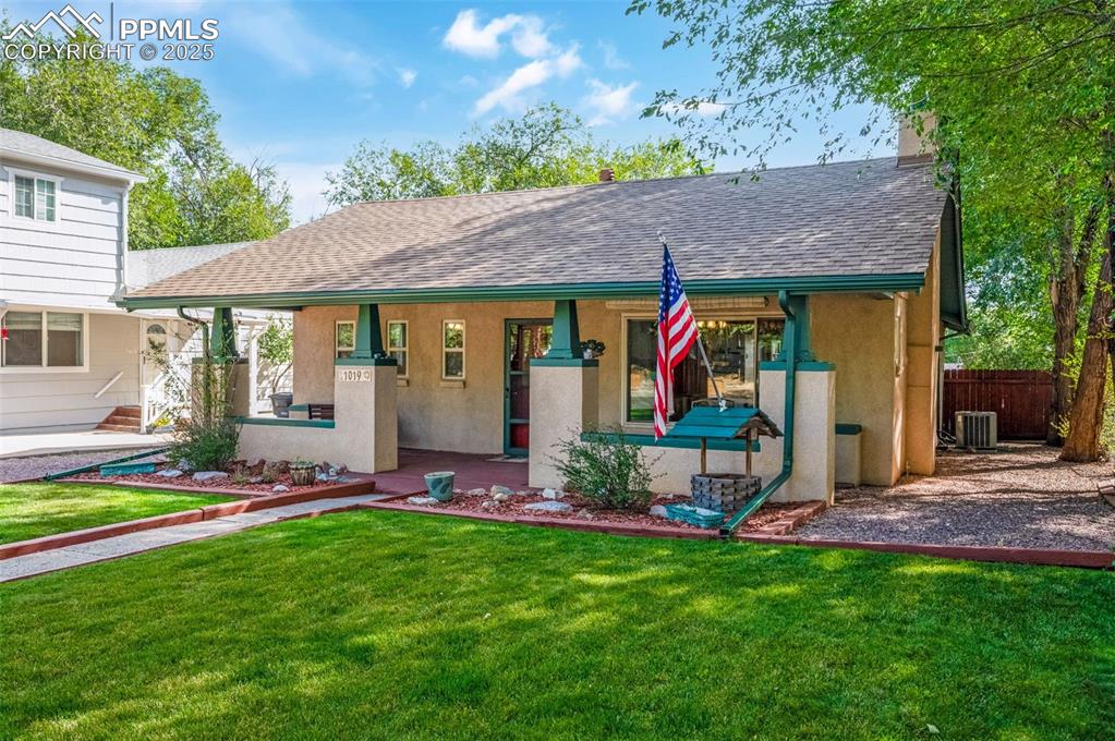 Image 2 of 27: View of front of property with a front lawn, covered porch, stucco siding, 