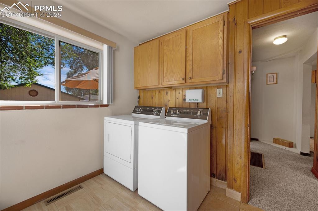 Image 21 of 27: Washroom featuring cabinet space, washing machine and dryer, light colored 
