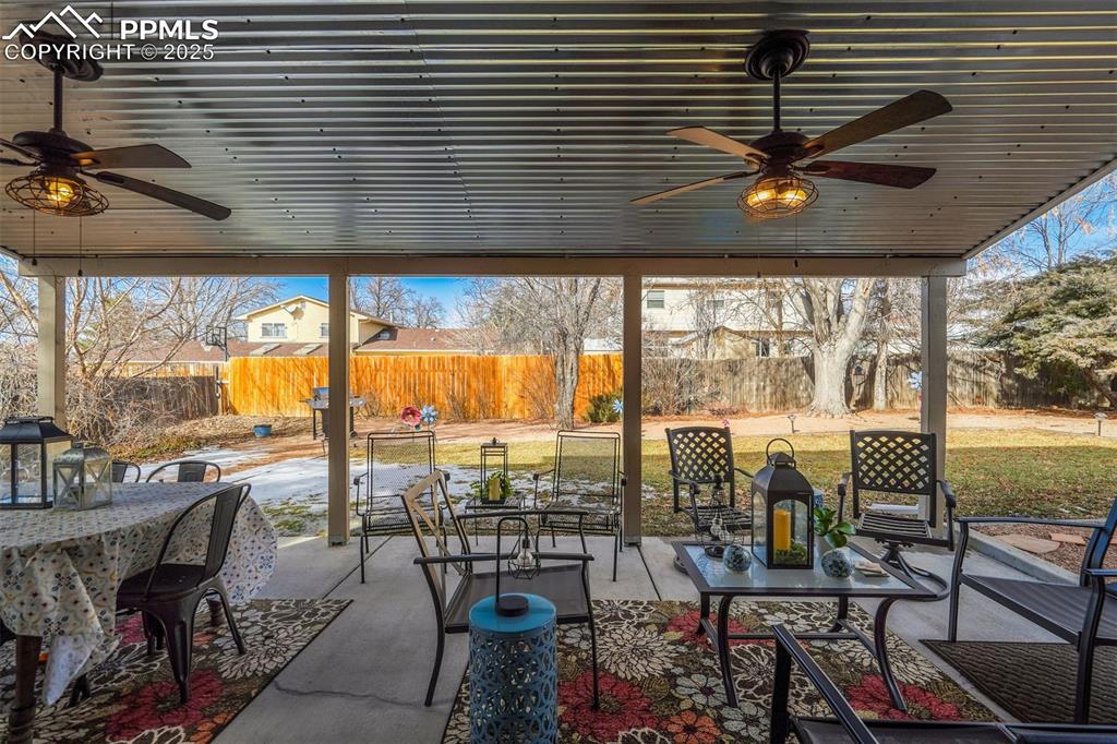 Image 31 of 50: View of patio / terrace with ceiling fan, outdoor dining space, and a fence