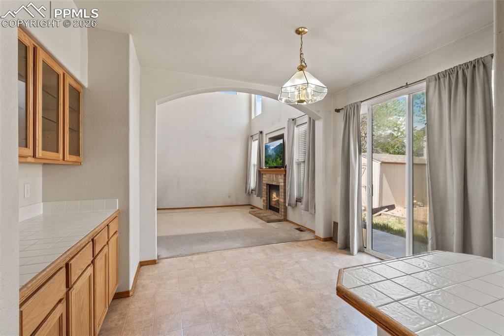 Image 13 of 40: Kitchenette featuring wood cabinetry, white tile countertops, and a tile-to