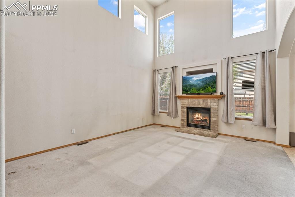 Image 15 of 40: Spacious living area featuring a floor-to-ceiling stone fireplace, prominen