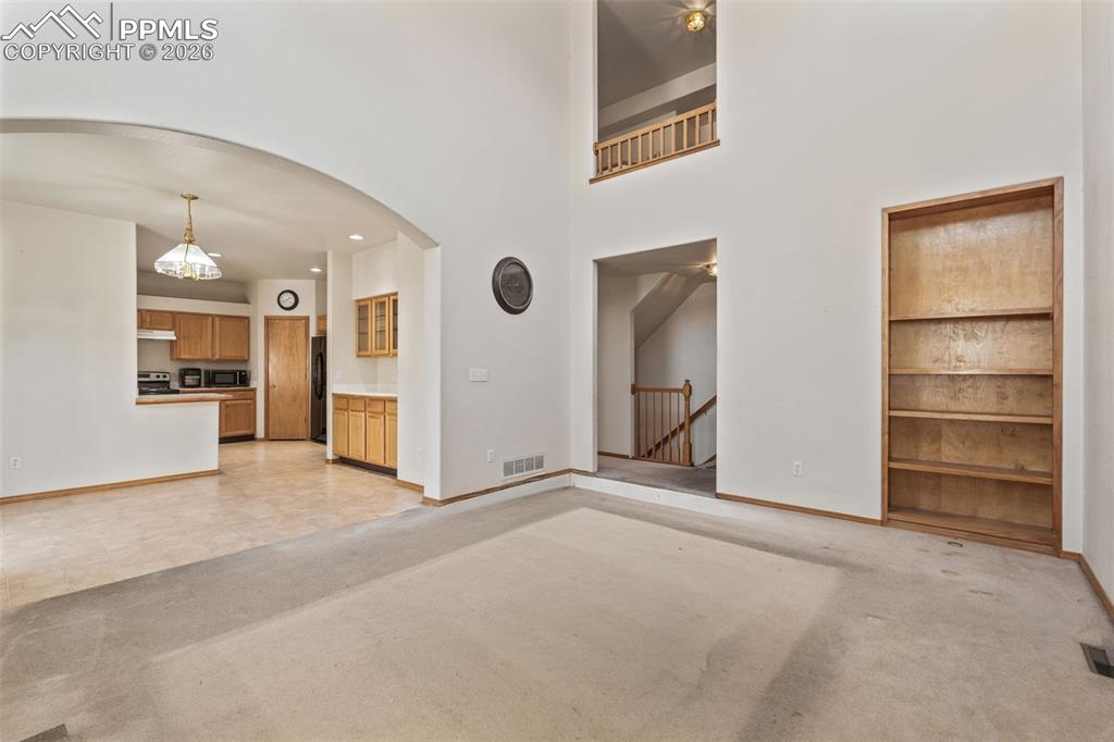 Image 17 of 40: Expansive main living area featuring a vaulted ceiling and a built-in woode