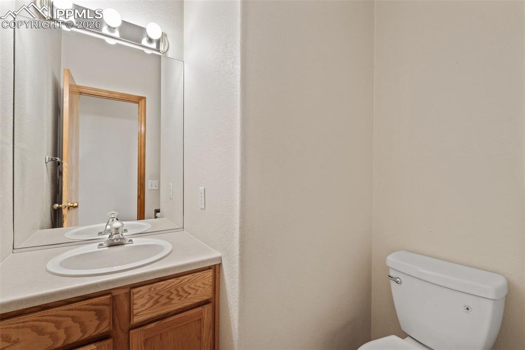 Image 19 of 40: Bathroom featuring a wood-finish vanity with a light countertop and an oval