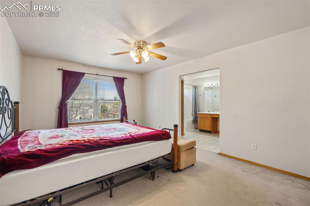 Image 22 of 40: Carpeted room with a ceiling fan, a window with blinds and purple drapes, a