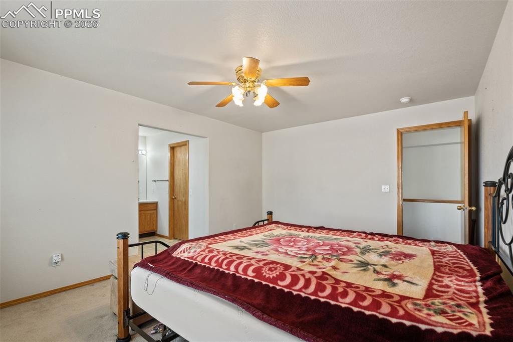 Image 25 of 40: Carpeted sleeping area featuring a ceiling fan with integrated lighting, wo