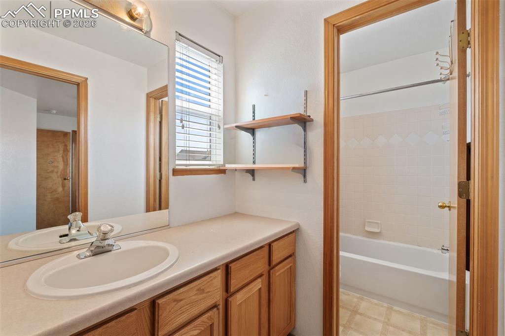 Image 29 of 40: Bathroom featuring a vanity with a laminate countertop, integrated oval sin