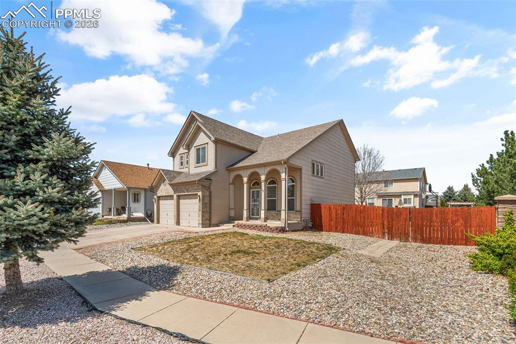Image 3 of 40: Two-story residence featuring a two-car garage, arched entry porch, light s