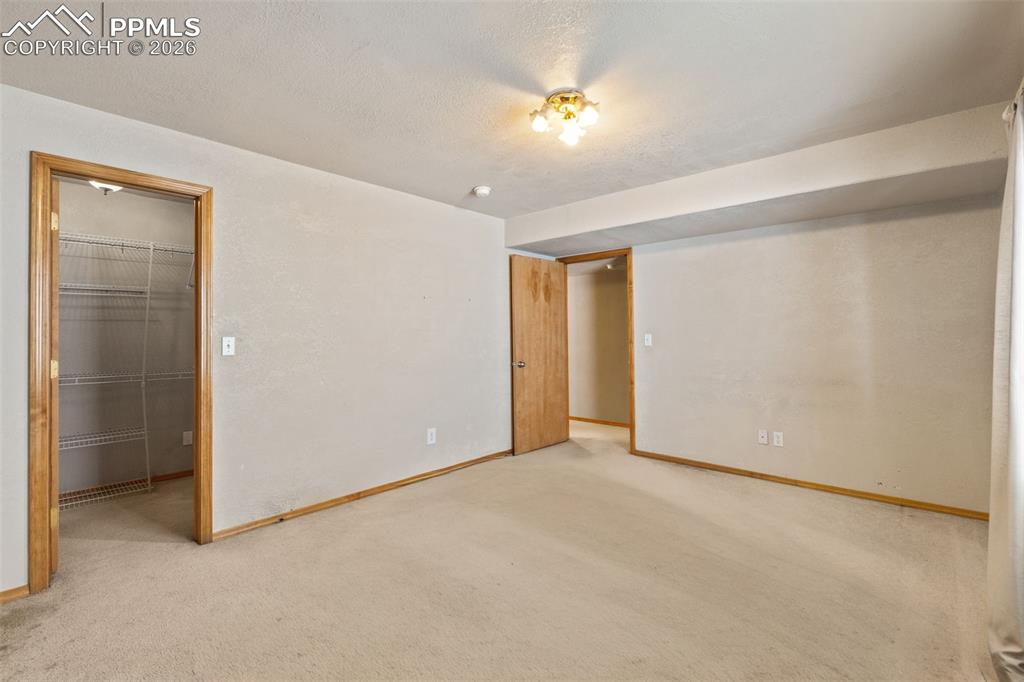 Image 35 of 40: Carpeted room with a ceiling-mounted light fixture, light-toned walls, and 