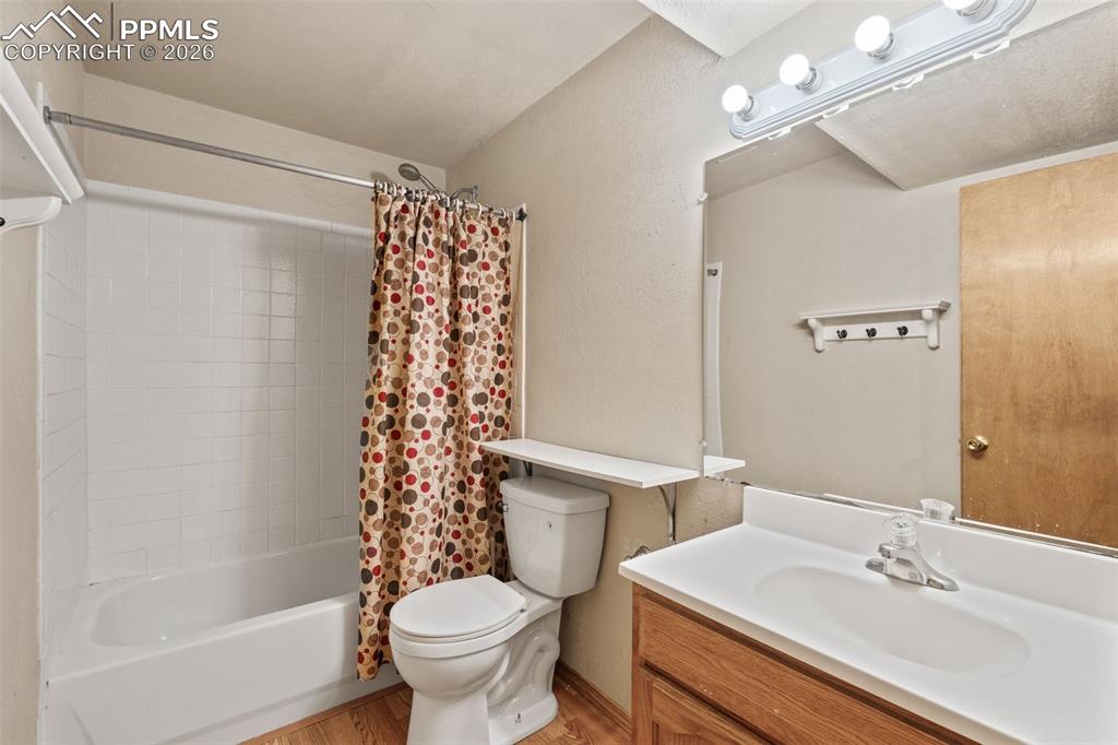 Image 36 of 40: Bathroom featuring a shower/tub combination with white tile surround, a woo