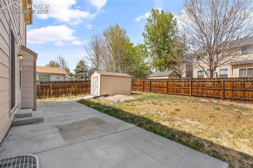 Image 38 of 40: Expansive backyard featuring a concrete patio, a storage shed, and a privac