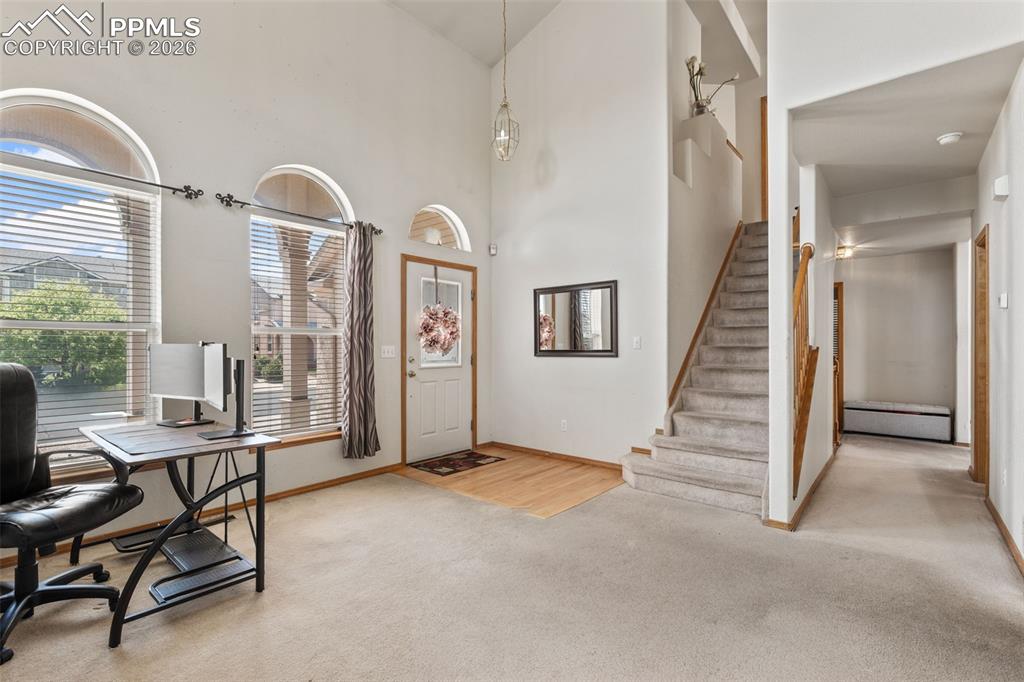 Image 8 of 40: Entryway featuring vaulted ceilings, arched windows, light wood-finish floo