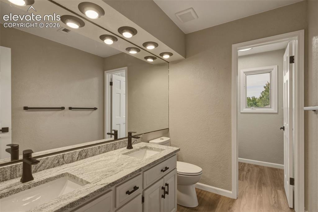 Image 15 of 32: Double vanity with integrated sinks, granite-look countertop, white cabinet