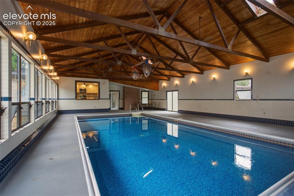 Image 3 of 32: Indoor swimming pool featuring a vaulted wood-finish ceiling, exposed woode